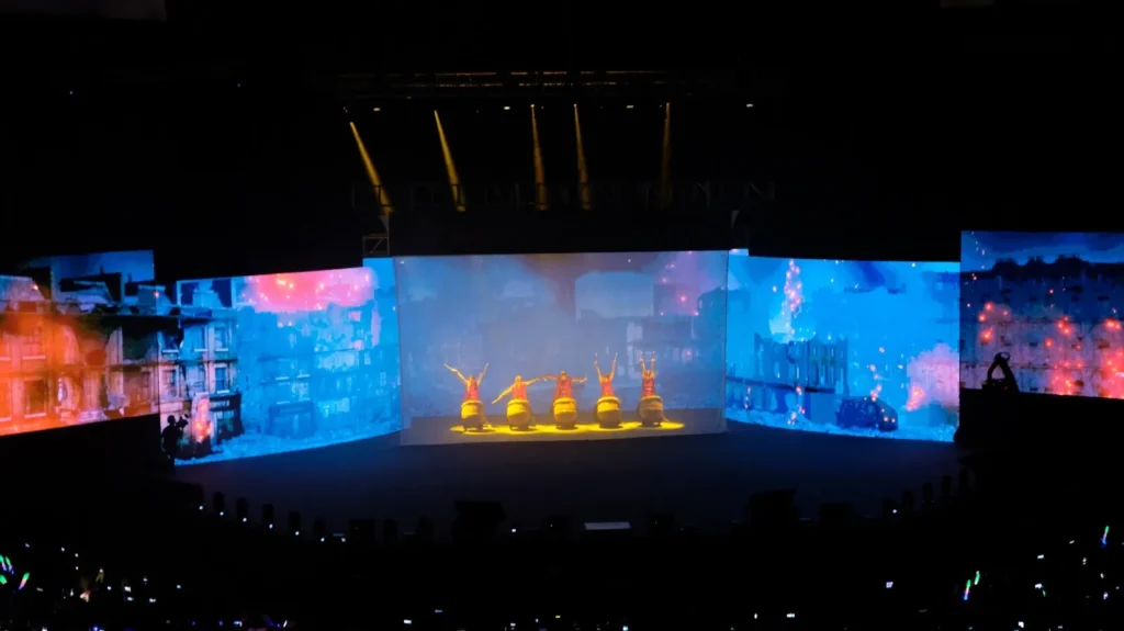 Dancers on the Auditorium stage in front of large LED screens