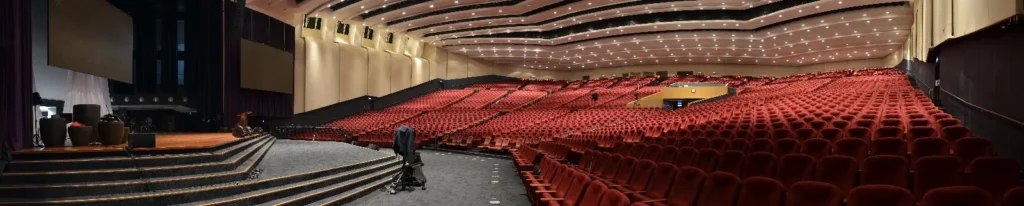 Rows of empty red seats in the Auditorium seen from the side of the stage
