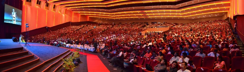 Full Auditorium under warm red and orange lighting during an event