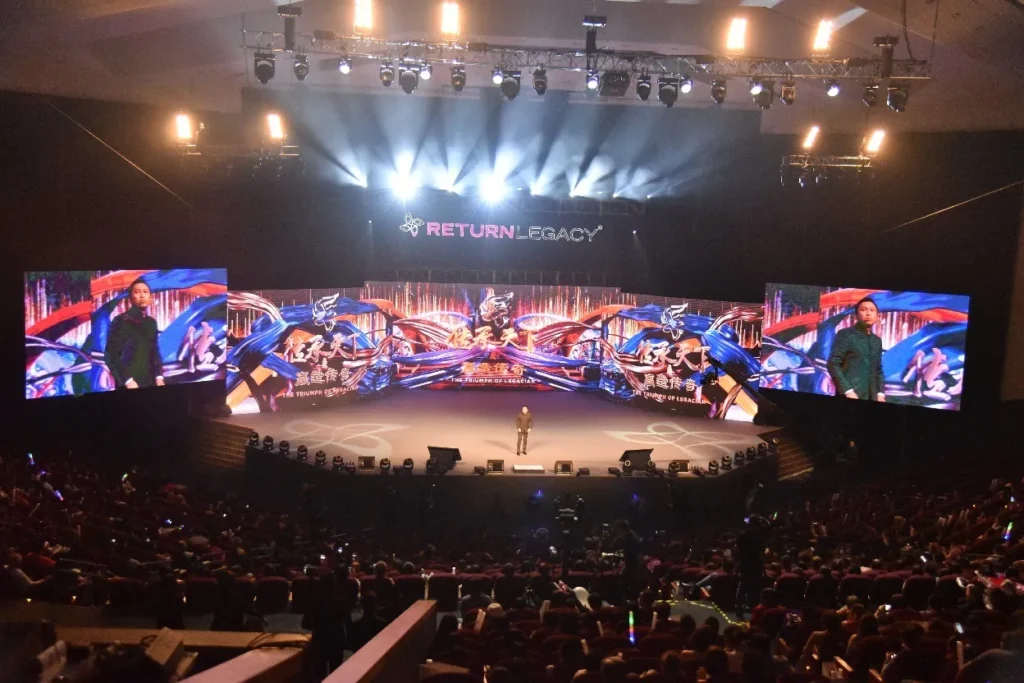 Wide view of the Auditorium stage and its long LED screen at a Return Legacy event