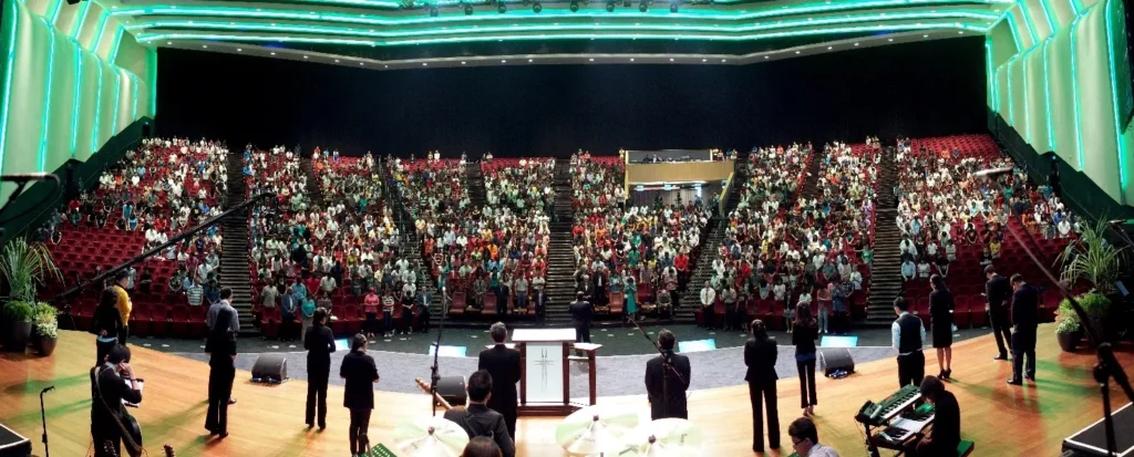 View from the Auditorium stage towards a full audience, with performers in the foreground