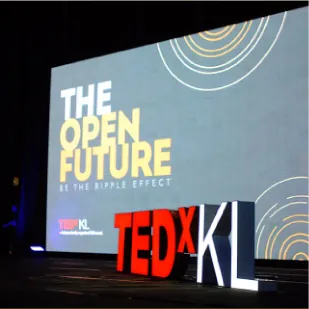 TEDxKL letters and The Open Future screen on the Auditorium stage