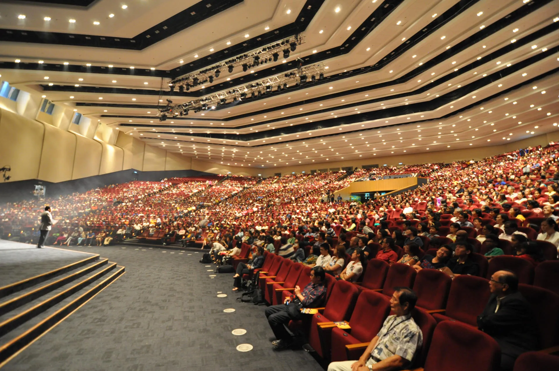 Full audience in the Auditorium's tiered seating, seen from beside the stage
