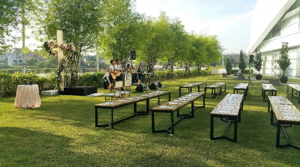 Rows of benches set for a wedding on the Garden lawn in late afternoon light