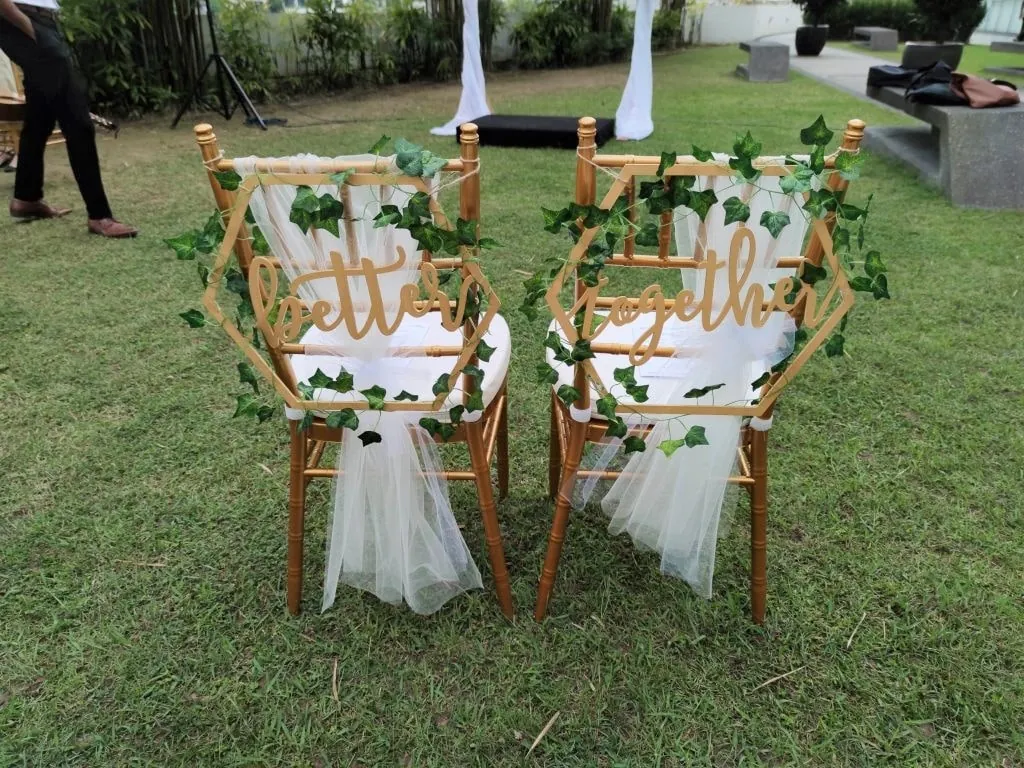 Two gold chairs with Better Together signs and greenery on the Garden lawn