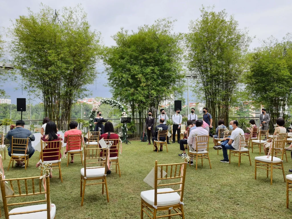 Wedding ceremony on the Garden lawn with guests in gold chairs and bamboo behind
