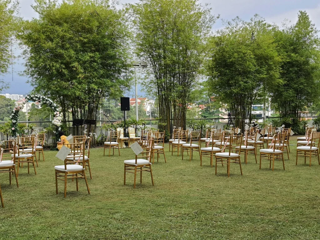 Gold chairs spaced out on the Garden lawn before a wedding ceremony