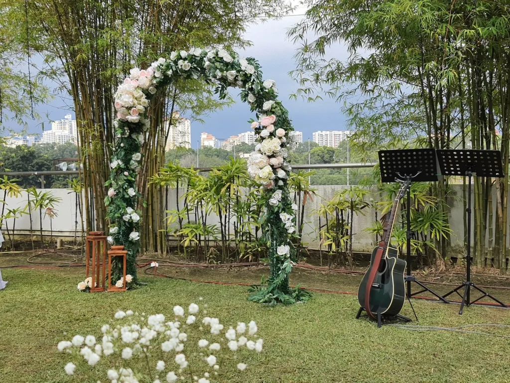 Floral arch, music stands and a guitar set up for a wedding in the Garden
