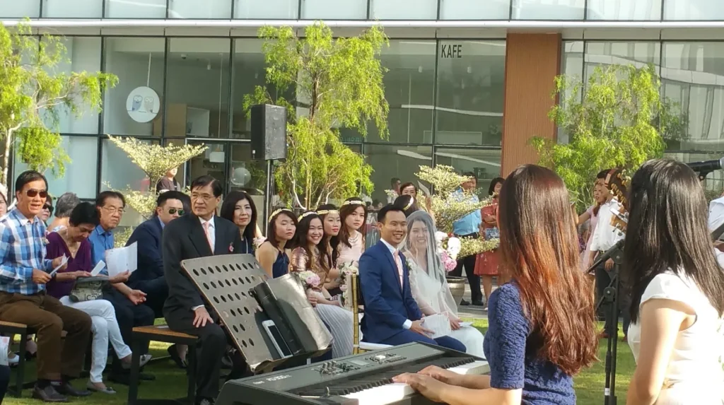 Wedding guests seated near a keyboard player in the Garden