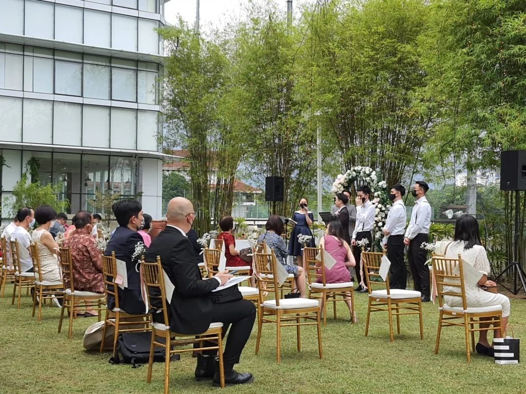 Guests seated on gold chairs on the Garden lawn during a wedding ceremony