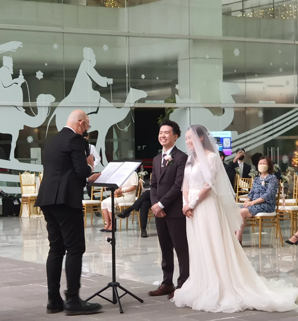 Officiant reading beside a bride and groom at their wedding ceremony in the Garden