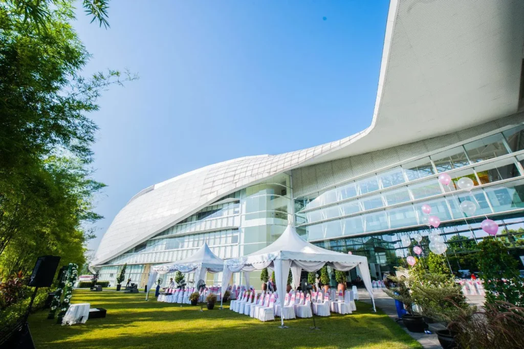 White wedding tents and chairs on the Garden lawn beside the curved building facade