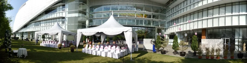 Wide view of wedding tents on the Garden lawn in front of the building