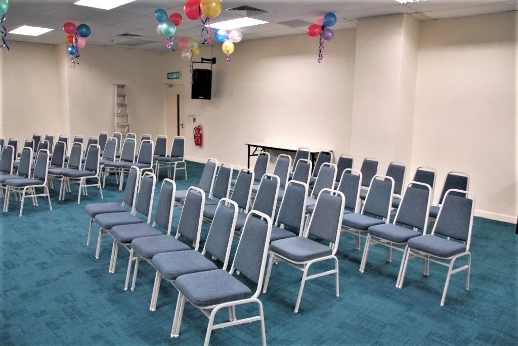 Rows of chairs under balloon decorations in a meeting room
