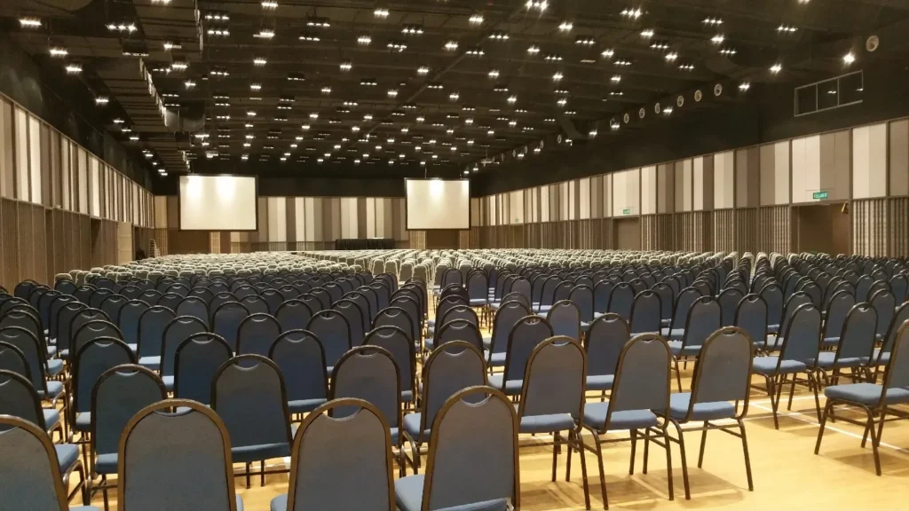 Rows of blue conference chairs facing two screens in the Multipurpose Banquet Hall