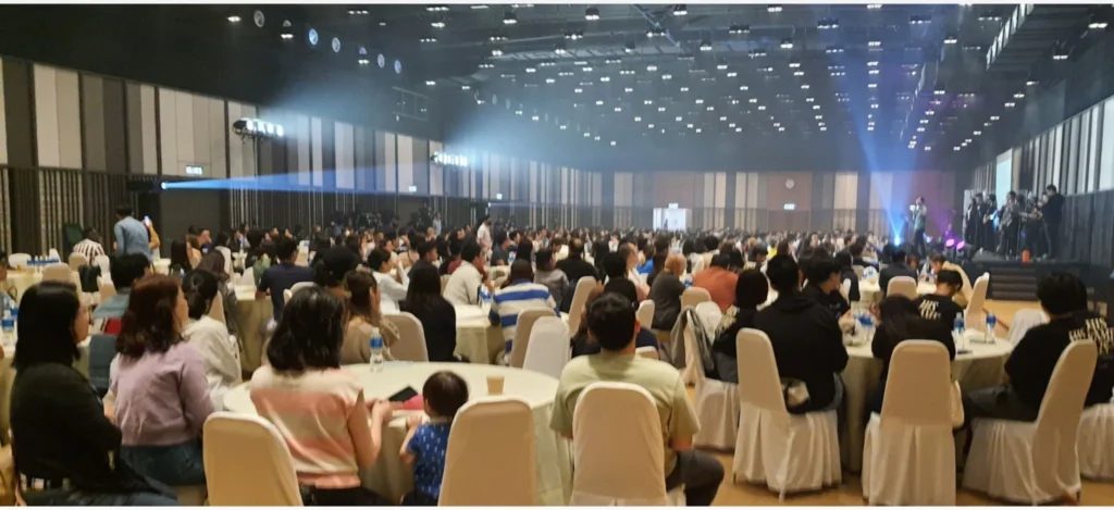 Guests at round tables watching a band on stage at a conference in the Multipurpose Banquet Hall