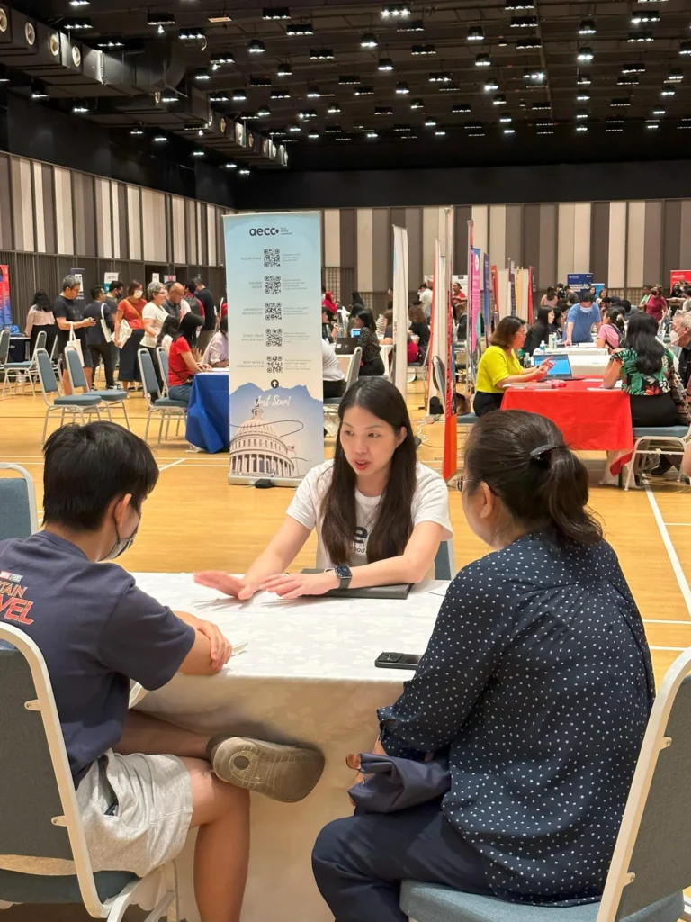 Student and parent meeting a university representative at an education fair in the Multipurpose Banquet Hall