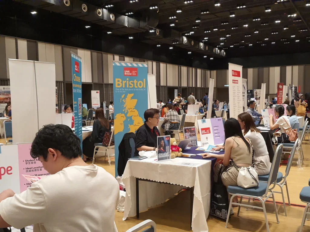 Visitors at university booths during an education fair in the Multipurpose Banquet Hall