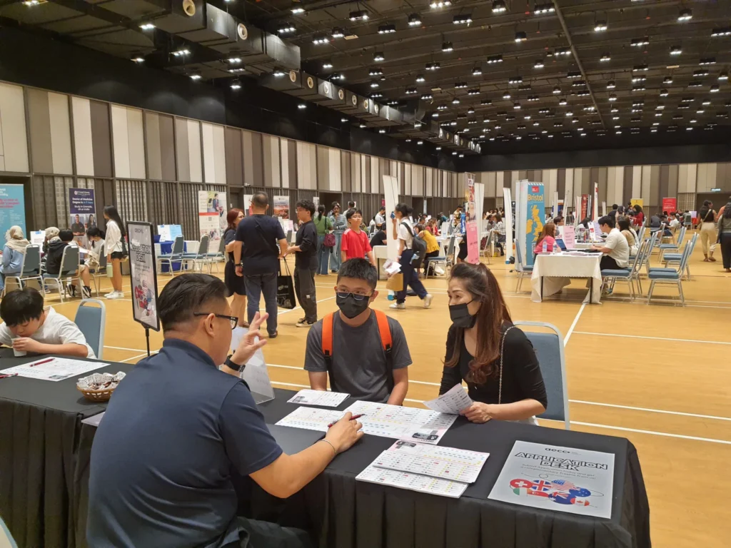 Counsellor advising a student and parent at an education fair in the Multipurpose Banquet Hall