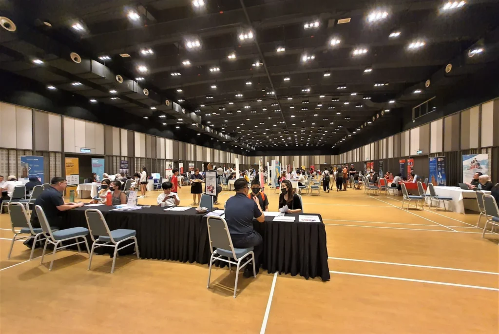Wide view of exhibitor tables at an education fair in the Multipurpose Banquet Hall