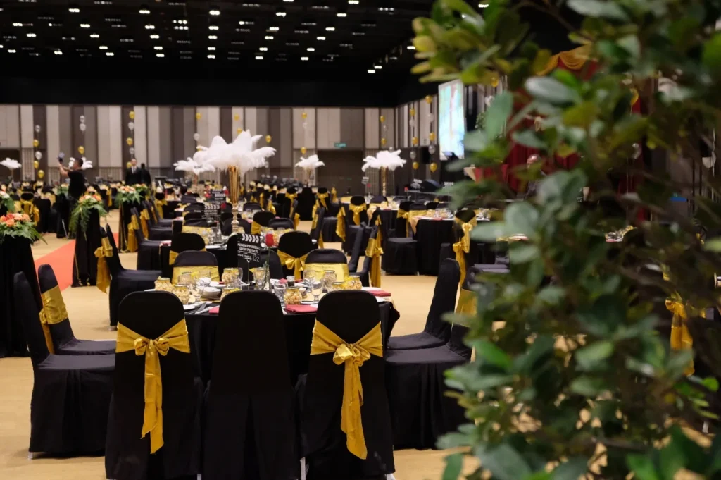 Black chair covers with gold sashes around a wedding table in the Multipurpose Banquet Hall