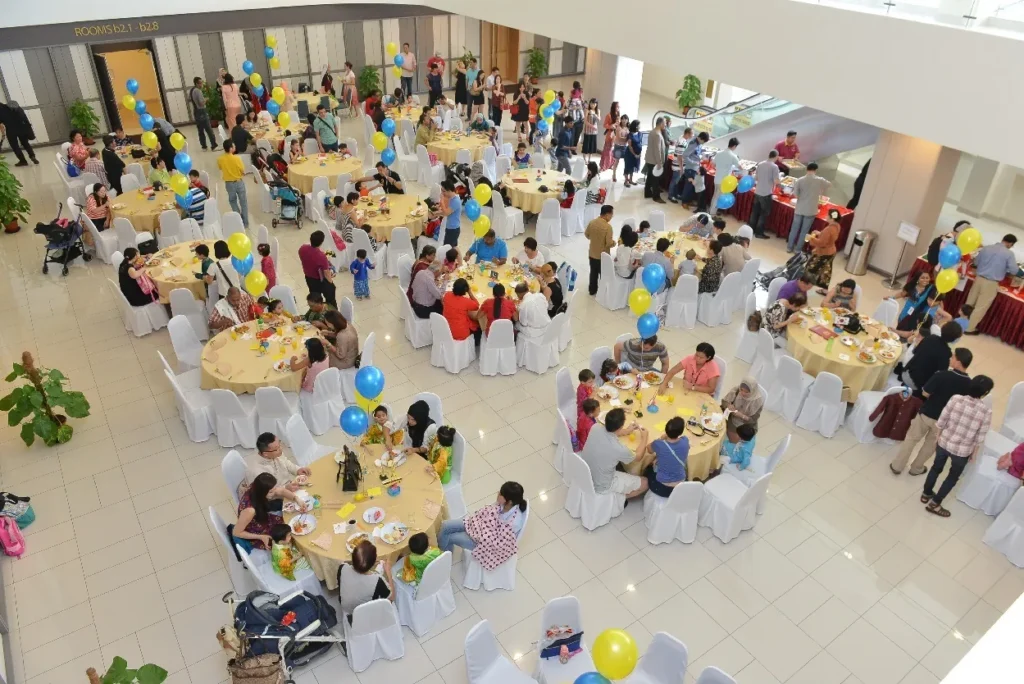 Families at balloon-decorated buffet tables in the Multipurpose Banquet Hall lobby, seen from above