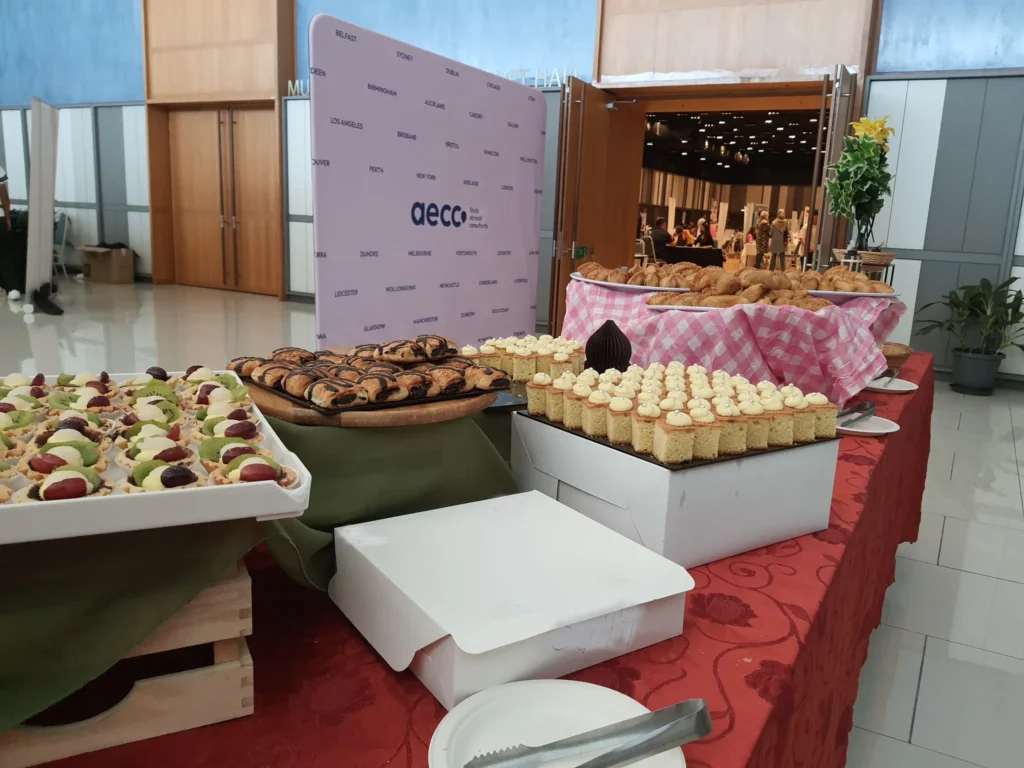 Pastries and desserts laid out on a buffet table in the Multipurpose Banquet Hall lobby at an AECC event