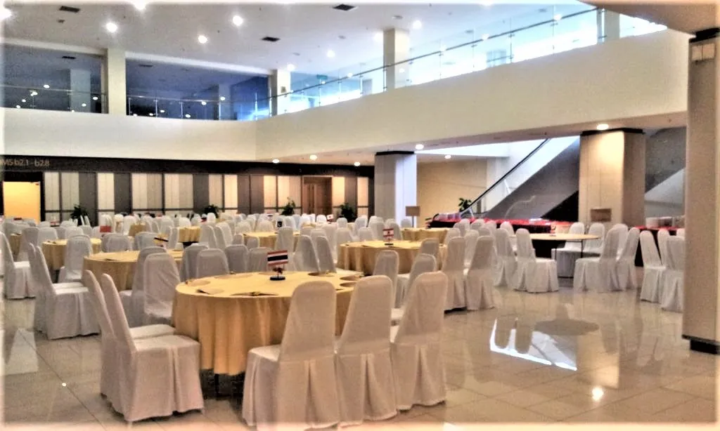Round tables with gold cloths and white chairs set for an event buffet in the Multipurpose Banquet Hall lobby