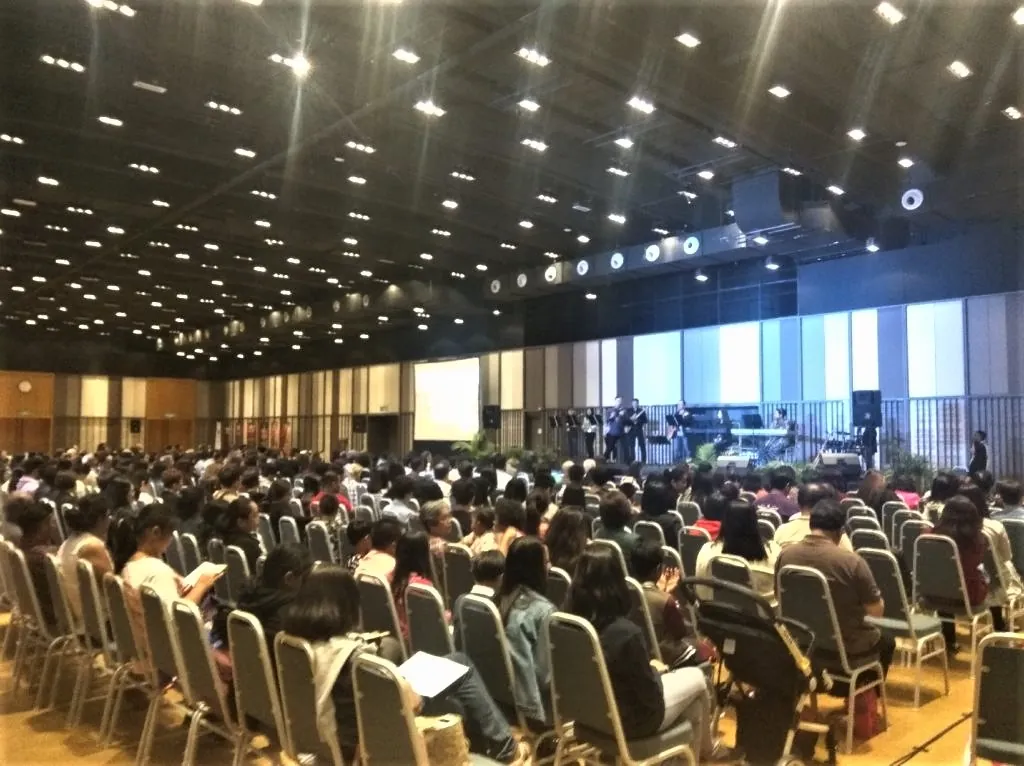 Seminar audience in rows facing a stage with musicians in the Multipurpose Banquet Hall