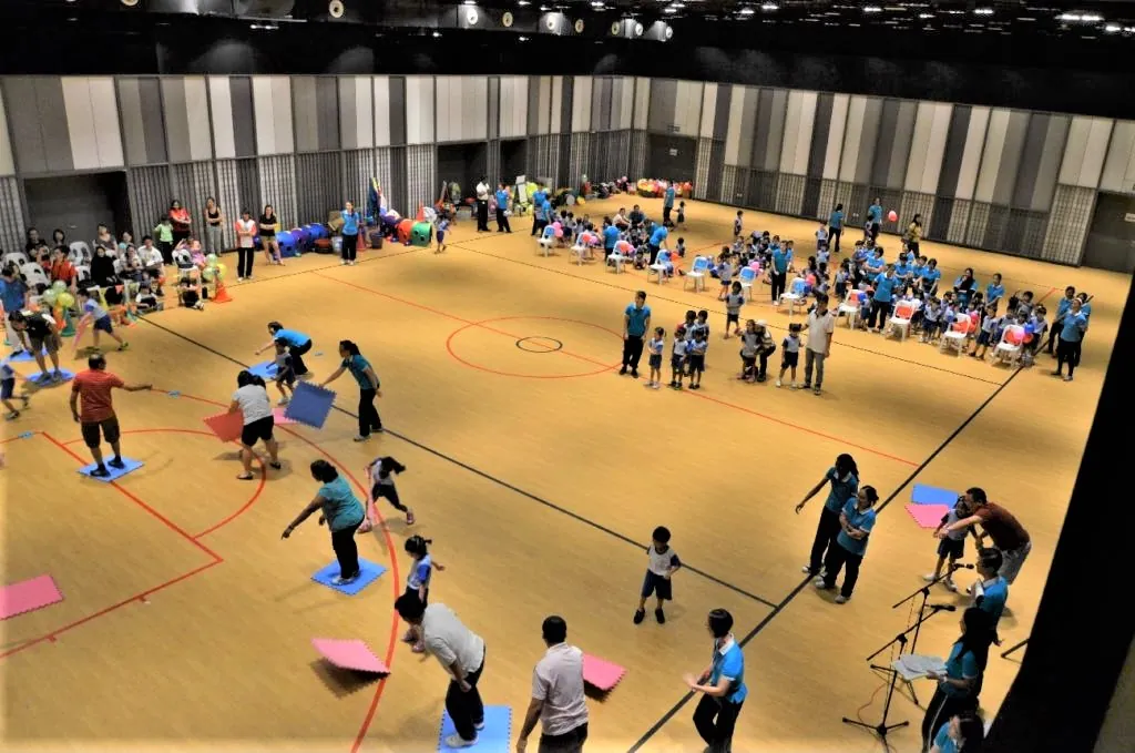 Teachers and children running relay games at a kindergarten sports day in the Multipurpose Banquet Hall
