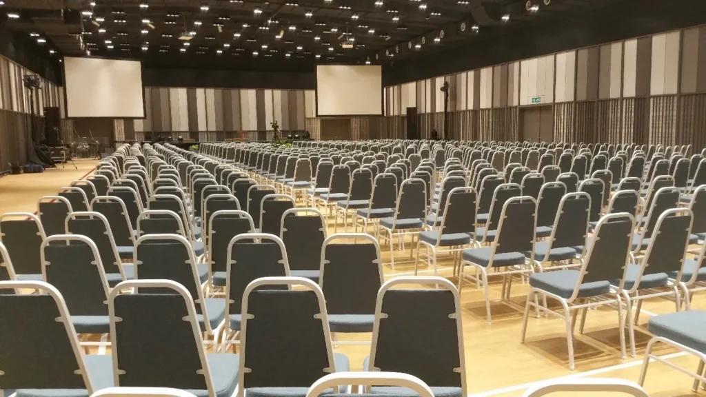 Theatre-style rows of chairs facing two projector screens in the Multipurpose Banquet Hall
