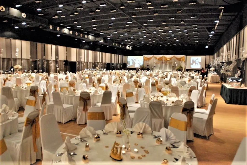Wedding banquet tables with white chair covers and gold sashes in the Multipurpose Banquet Hall