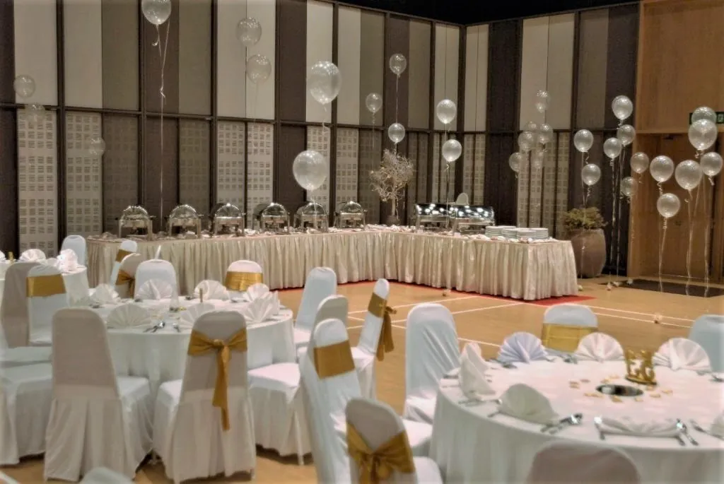 Wedding buffet table with clear balloons beside dining tables in the Multipurpose Banquet Hall