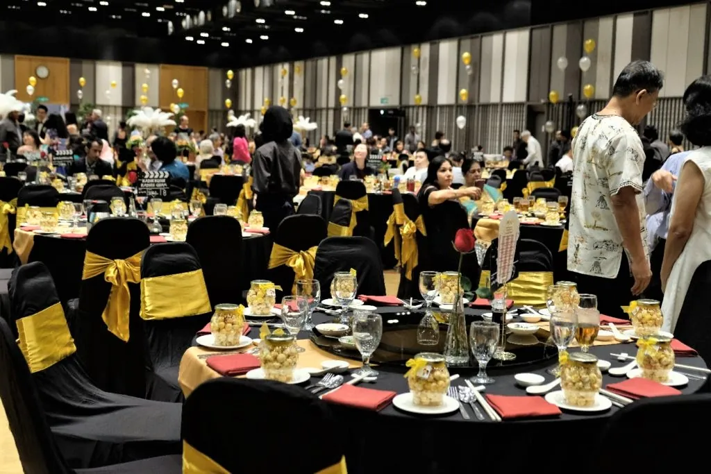 Wedding guests at black and gold dinner tables in the Multipurpose Banquet Hall