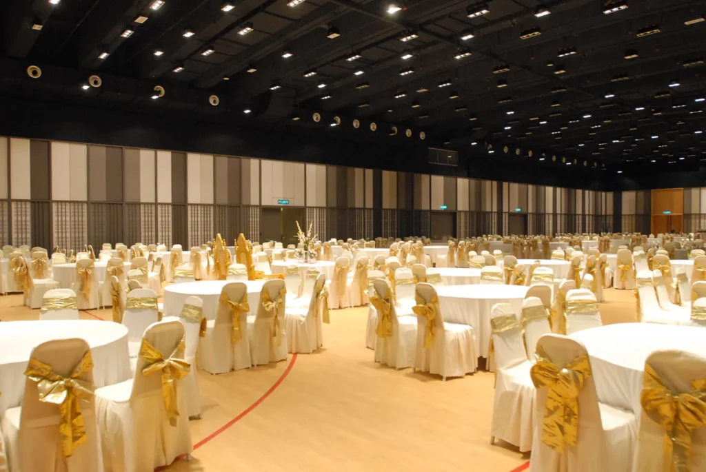 Round tables with gold bow chair covers for a wedding in the Multipurpose Banquet Hall