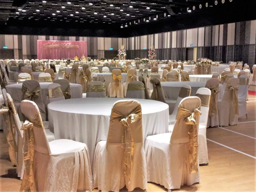 Wedding tables facing a pink stage backdrop in the Multipurpose Banquet Hall