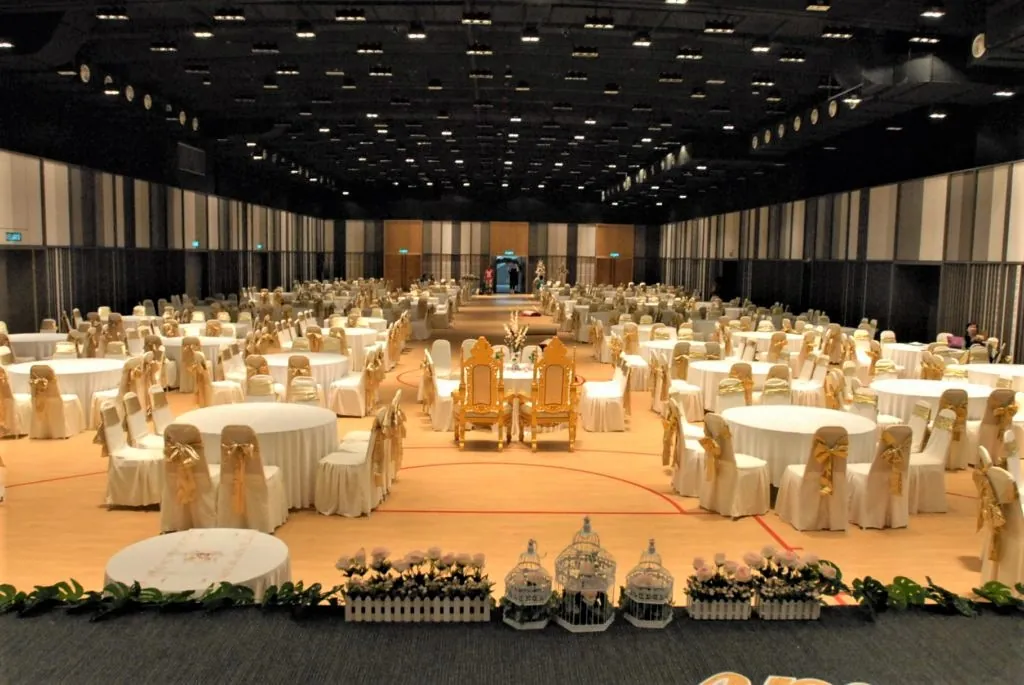 Wedding reception tables around a small stage with decorated chairs in the Multipurpose Banquet Hall
