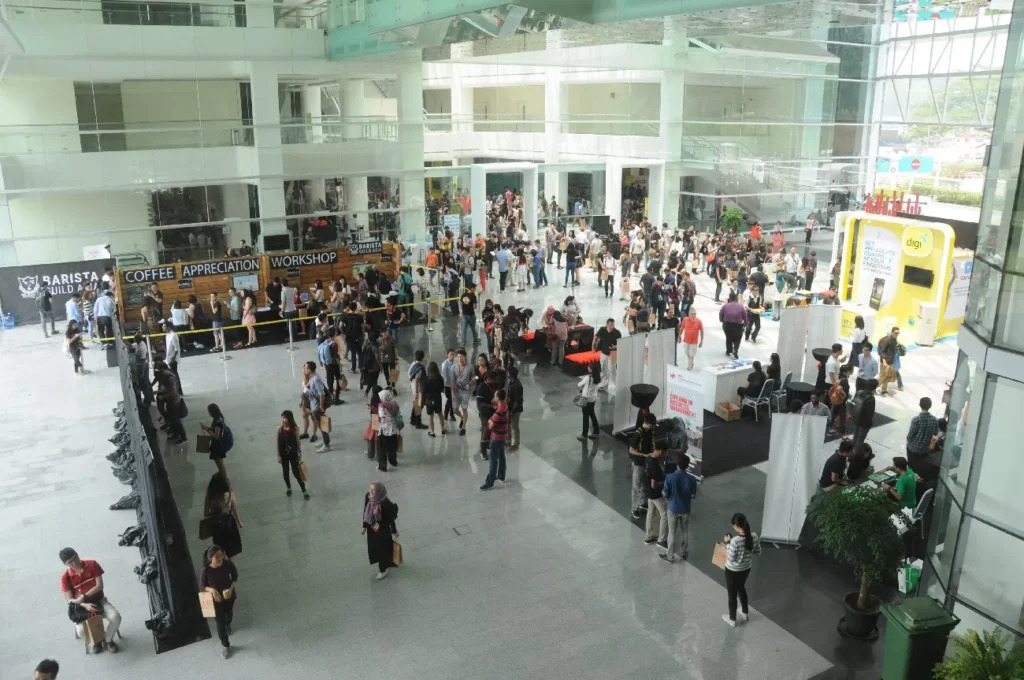 Visitors walking between exhibition booths in the Plaza