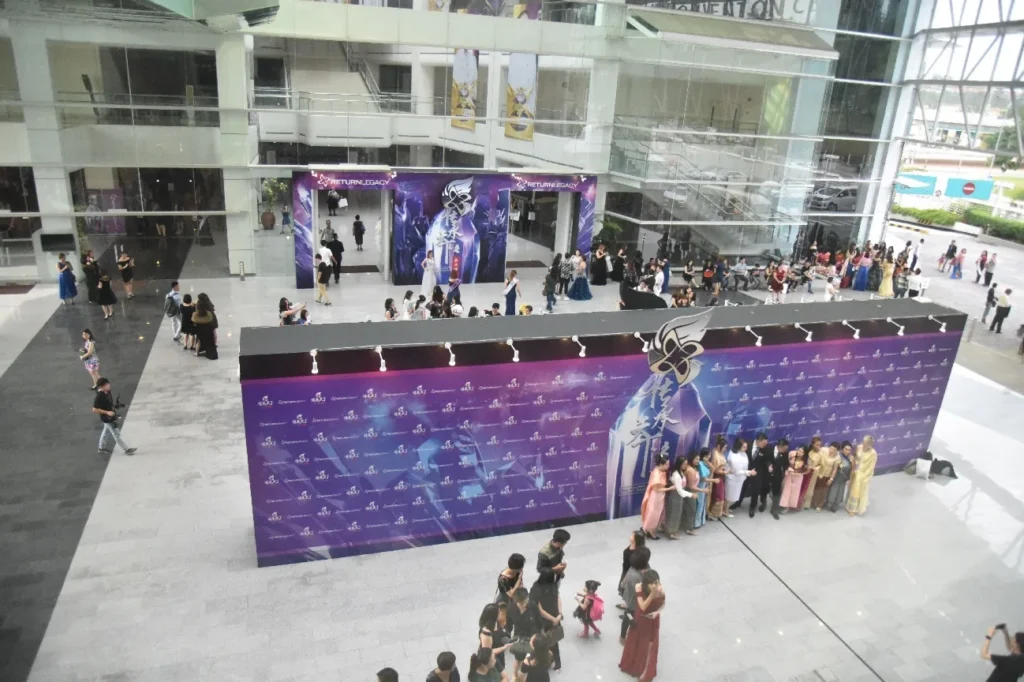 Guests posing at large event backdrops in the Plaza, seen from the level above