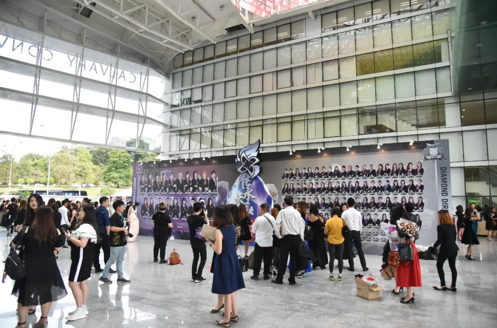 Guests at a company recognition night gathering by a photo wall in the Plaza
