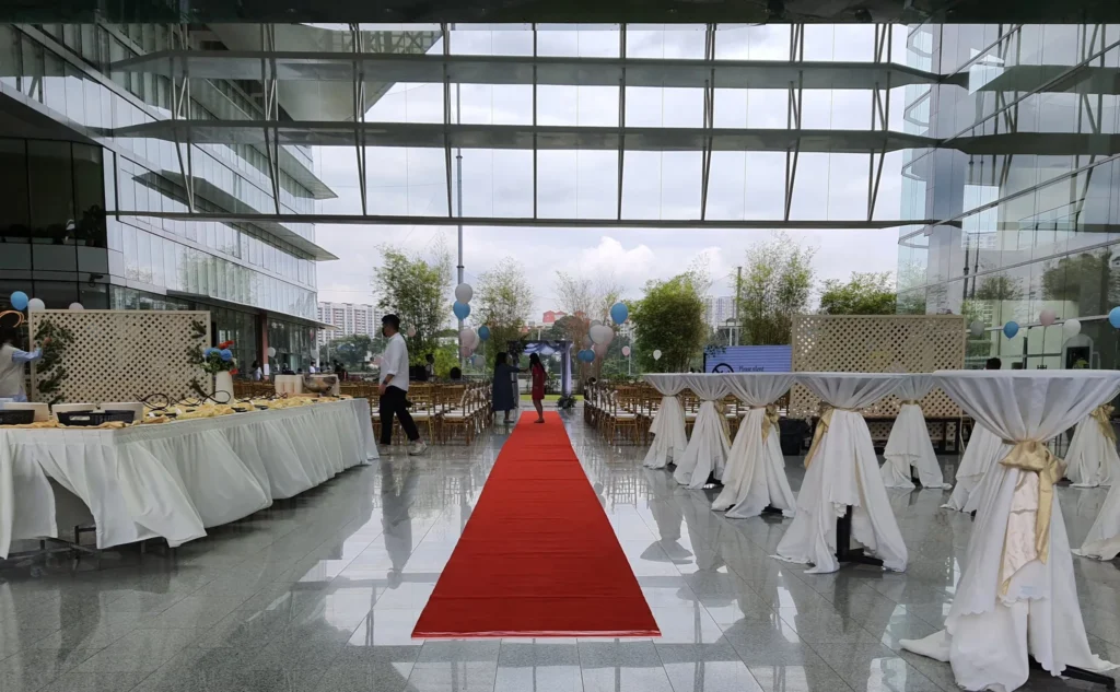 Red carpet aisle between draped tables set for a wedding in the Plaza