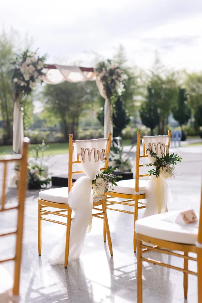 Wedding ceremony chairs with ribbon decorations and a floral arch in the Plaza