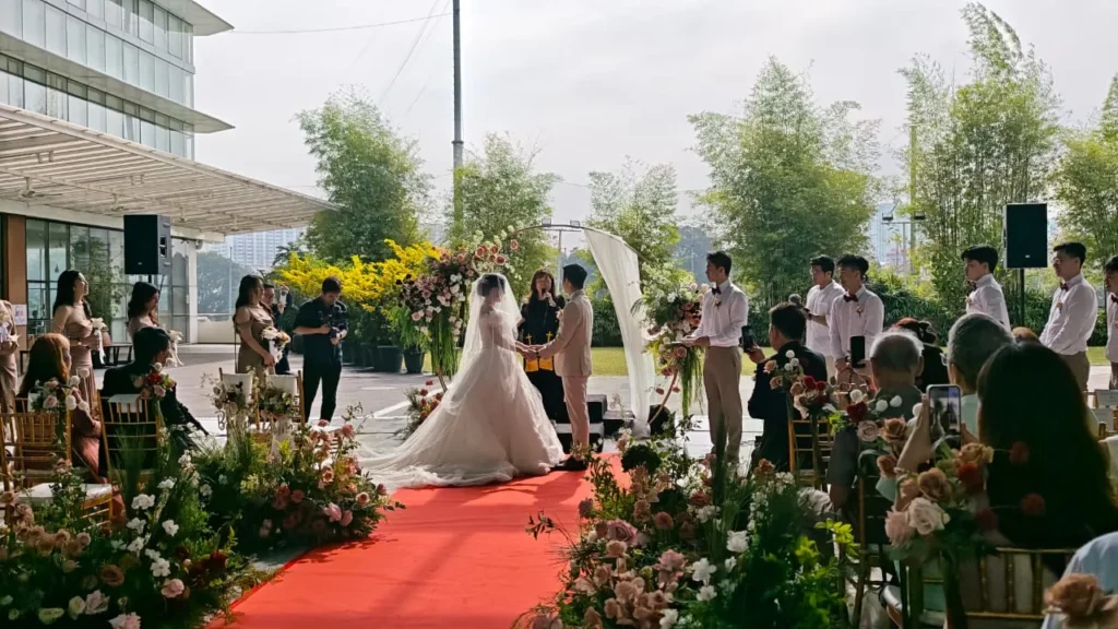 Wedding ceremony at the end of a flower-lined red carpet in the Plaza