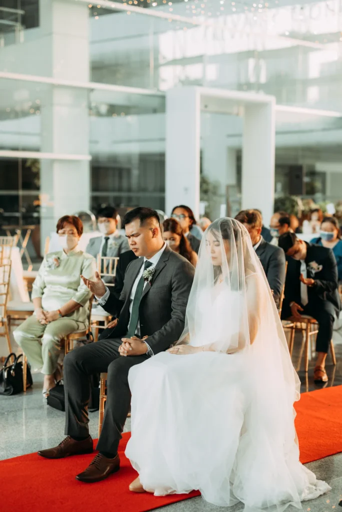 Bride and groom seated in the front row at their wedding ceremony in the Plaza