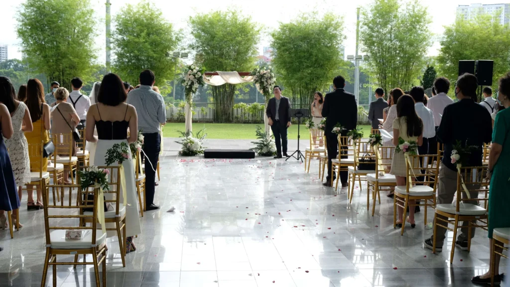 Guests standing at gold chairs during a wedding ceremony in the Plaza