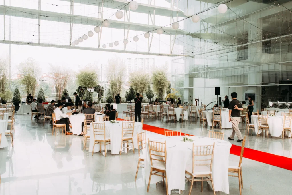 Paper lanterns above wedding tables and a red carpet aisle in the Plaza