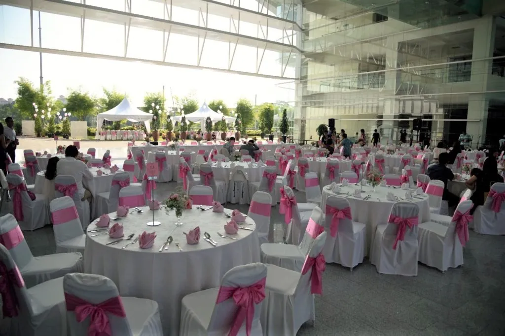 Round wedding reception tables with pink chair sashes in the Plaza