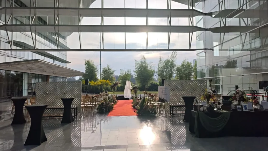 Wedding ceremony setup with a red carpet, lattice backdrop and cocktail tables in the Plaza