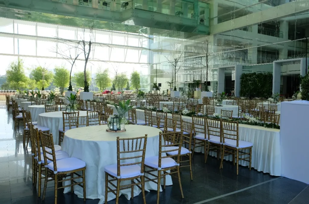 Wedding tables with white cloths and gold chairs in the Plaza, facing the garden