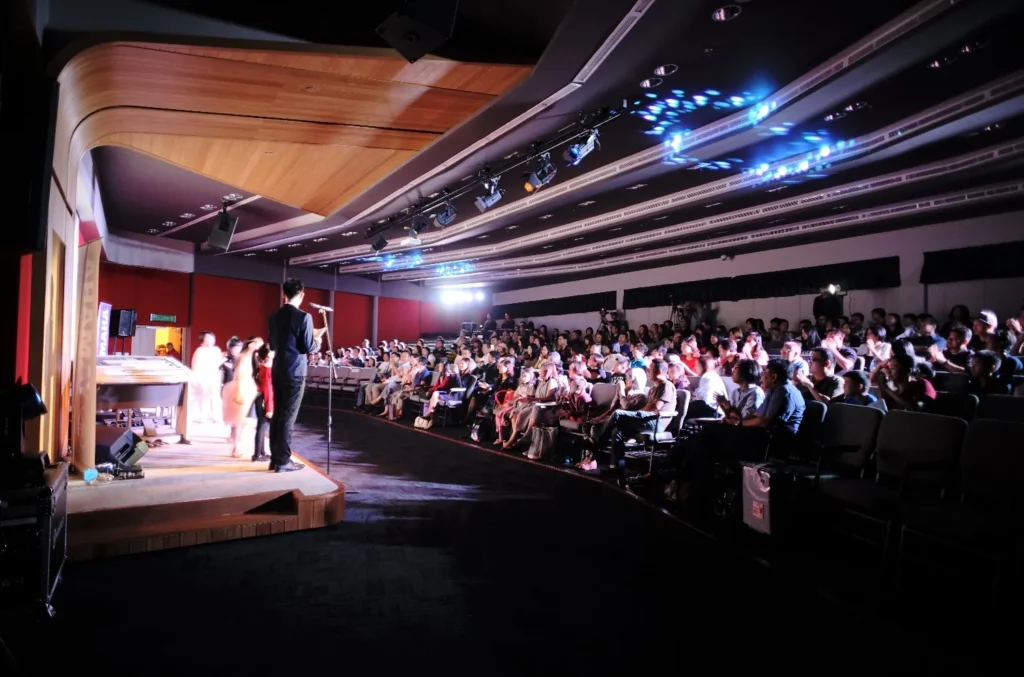 Performer on the Theatrette stage at the Yamaha Electone Festival, facing a full audience